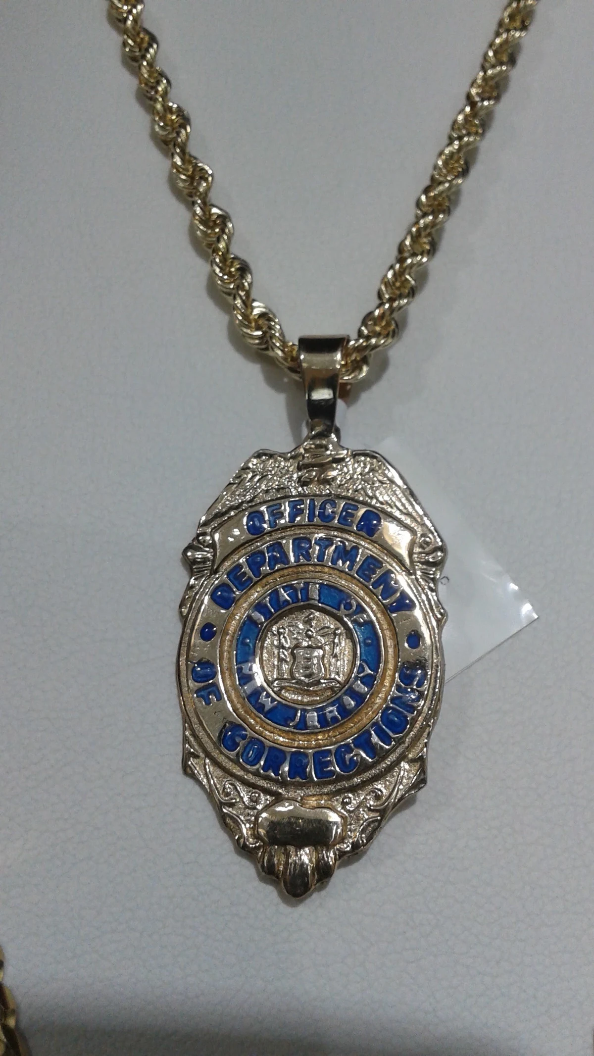 Custom gold New Jersey Department of Corrections officer badge pendant with blue enamel on a gold rope chain