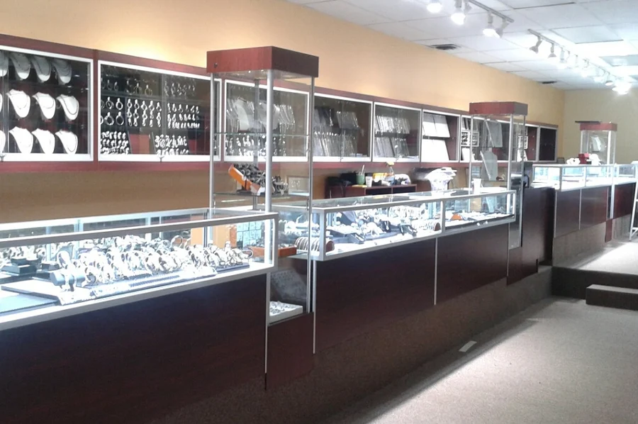 Long run of glass jewelry counters under track lighting
