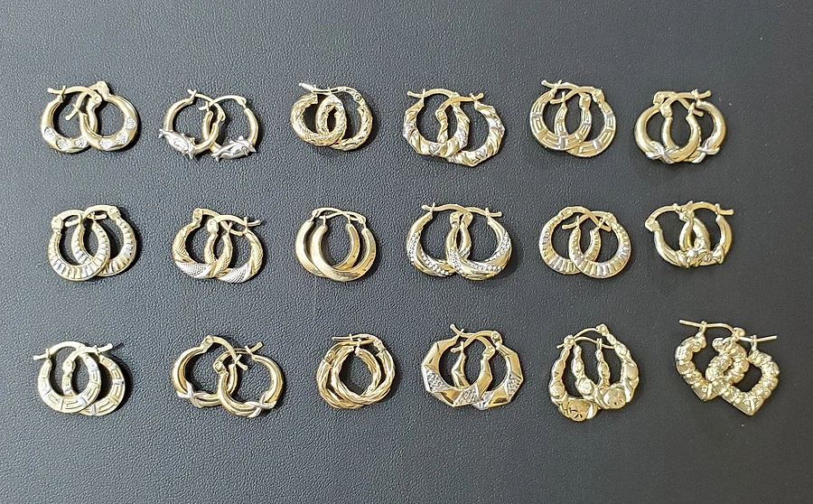 Eighteen pairs of gold hoop earrings in diamond-cut, twisted and heart styles