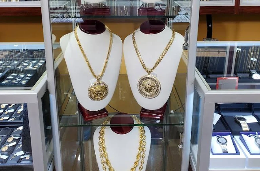 Gold chains with medallion pendants on display busts in the showroom case