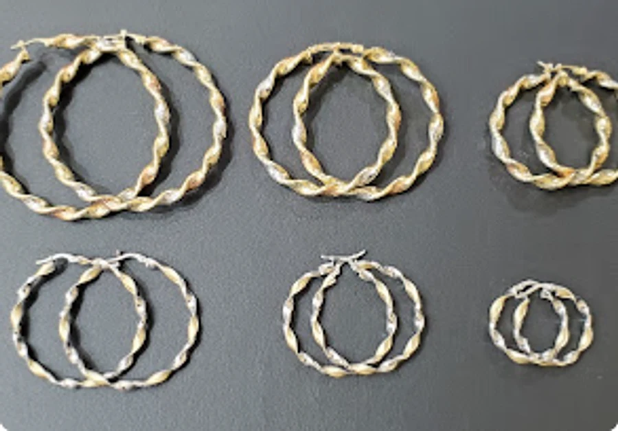 Six pairs of twisted two-tone gold hoop earrings
