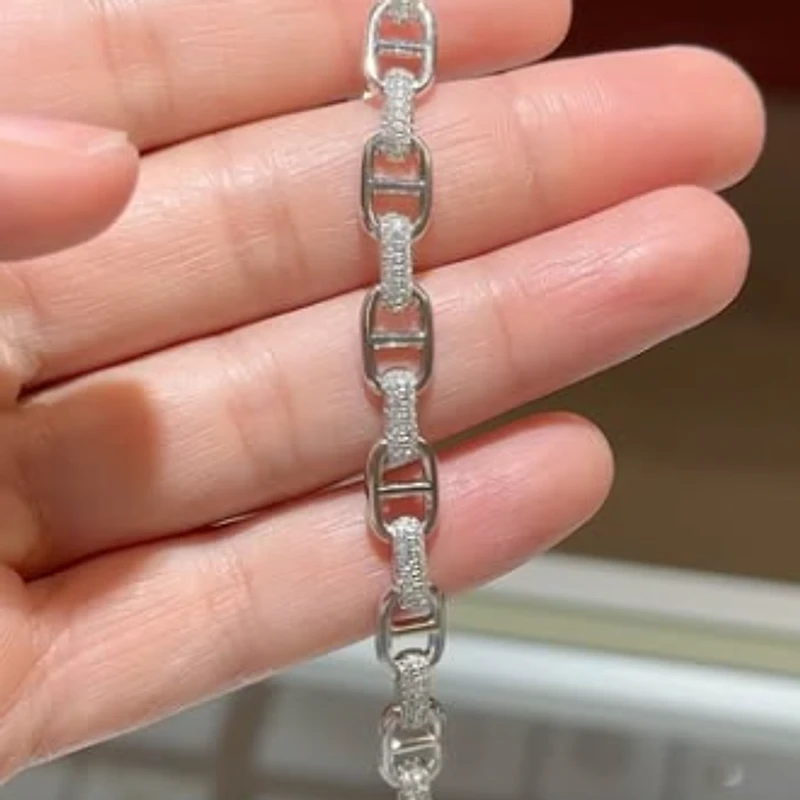 White gold mariner link bracelet with diamond-set bars held in a hand