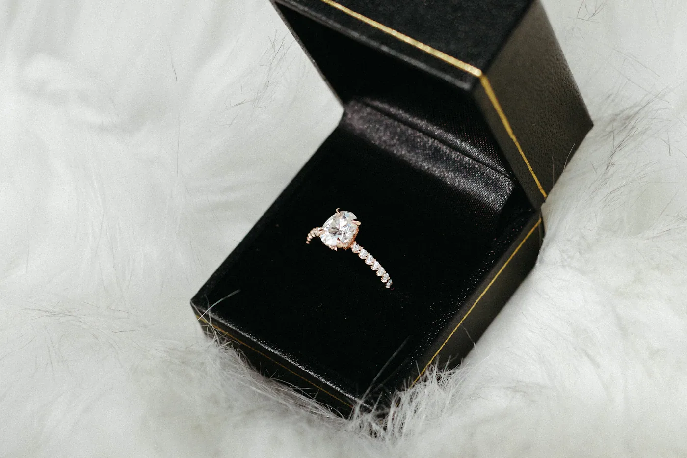 Diamond ring in a black gift box on soft white fur