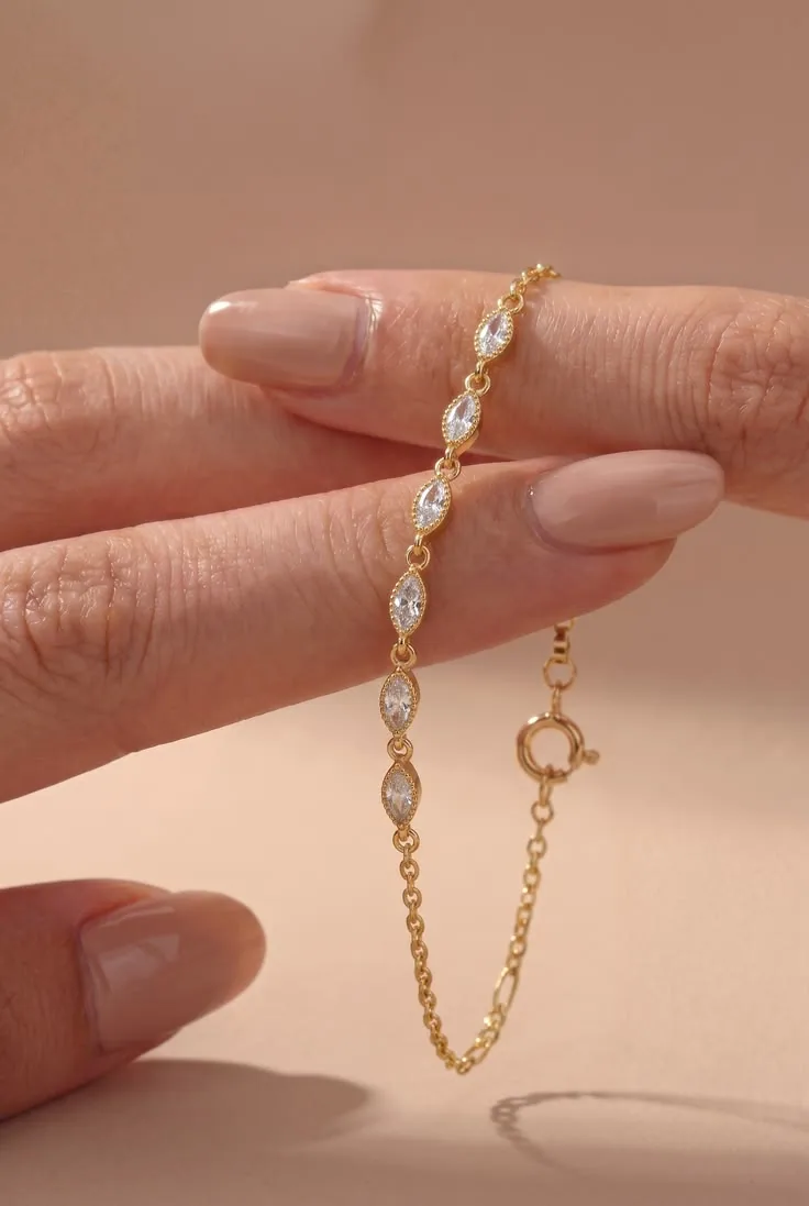 Gold bracelet with marquise-shaped gemstone links draped over fingers