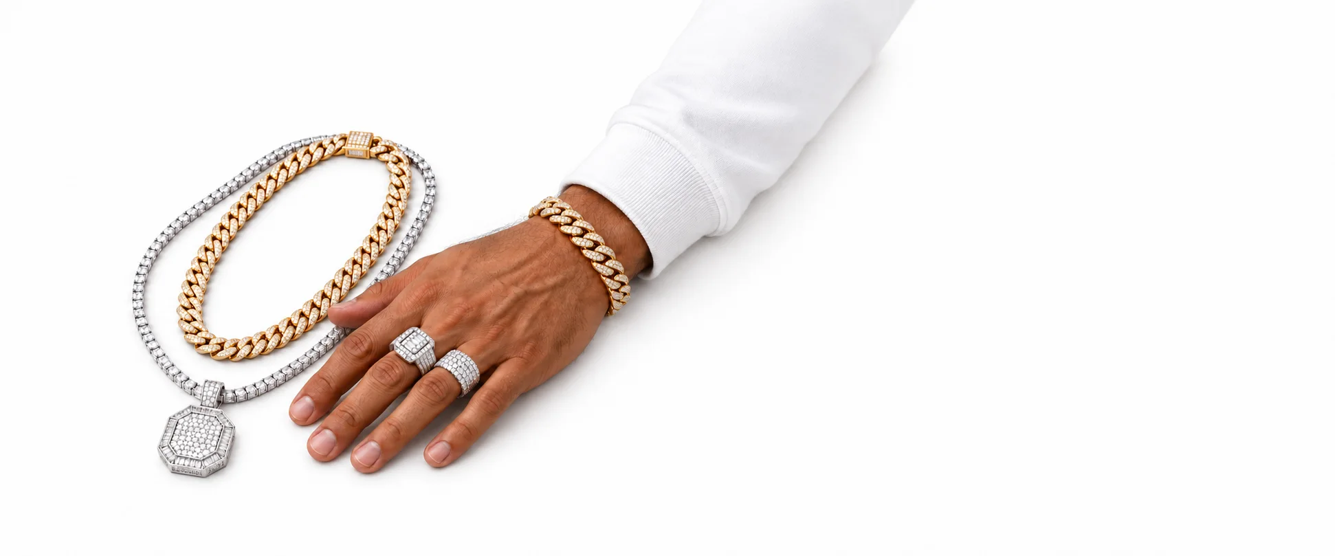 Hand wearing diamond rings and a gold Cuban link bracelet beside a gold Cuban chain and a diamond tennis chain with an octagon pendant